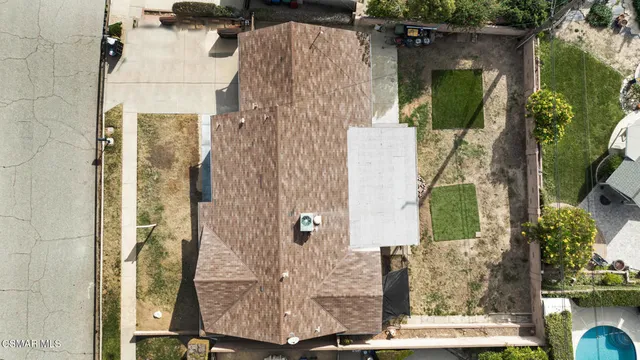 an aerial view of a house with garden space and a patio
