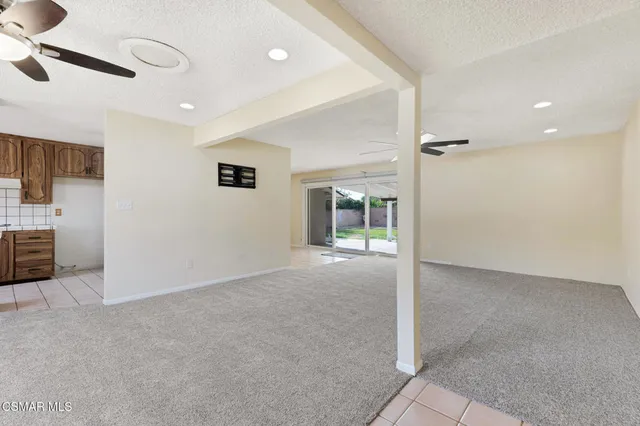 an empty room with a ceiling fan and windows