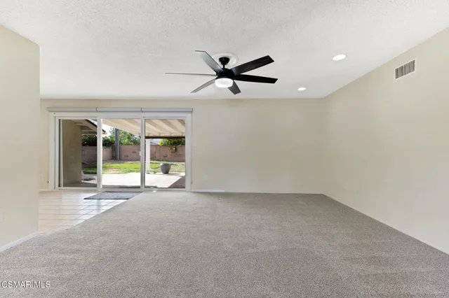 a view of a livingroom with a ceiling fan and window