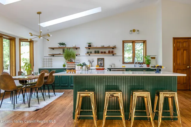 a dining hall with granite countertop a dining table chairs and large windows