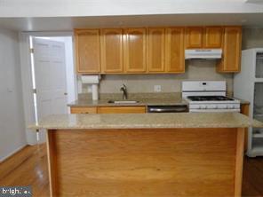 2349 South 11th Street, Unit 2 Philadelphia, PA 19148 - Photo 4 of 8 a kitchen with stainless steel appliances granite countertop a sink a stove and a refrigerator