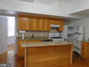 2349 South 11th Street, Unit 2 Philadelphia, PA 19148 - Photo 5 of 8 a kitchen with stainless steel appliances granite countertop a sink stove and cabinets