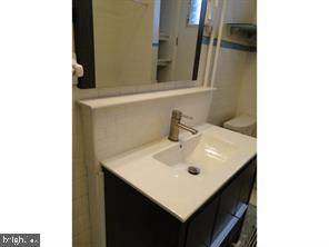 2349 South 11th Street, Unit 2 Philadelphia, PA 19148 - Photo 7 of 8 a bathroom with a sink and a mirror