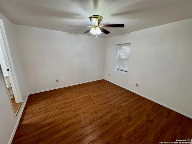 a view of empty room with wooden floor