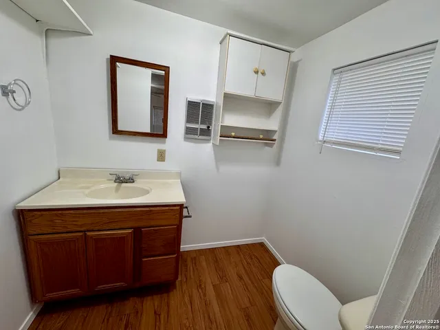a utility room with a sink a toilet and mirror