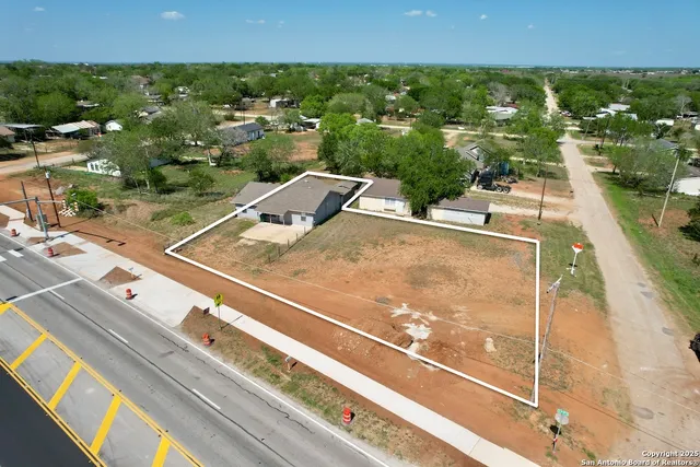 an aerial view of residential houses with outdoor space and street view