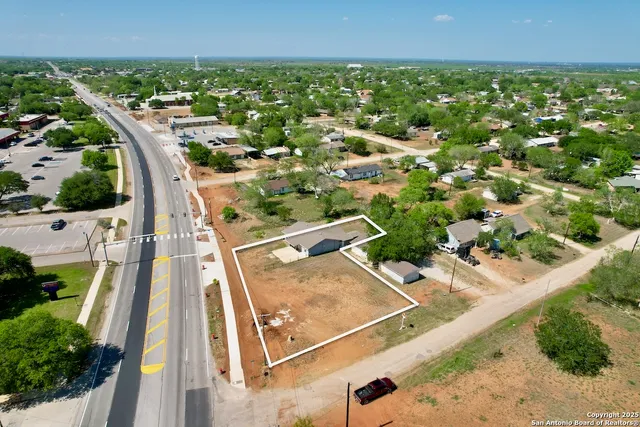 an aerial view of residential houses with outdoor space and street view