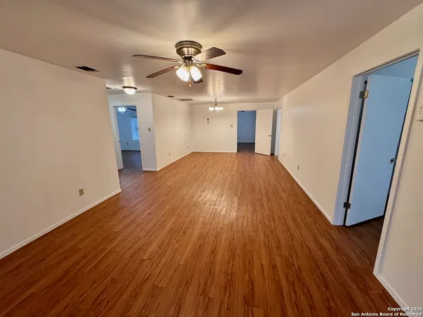 a view of empty room with wooden floor