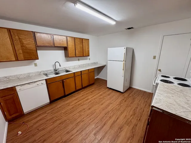 a kitchen with wooden floors and cabinets