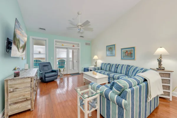 a living room with furniture a bed and wooden floor