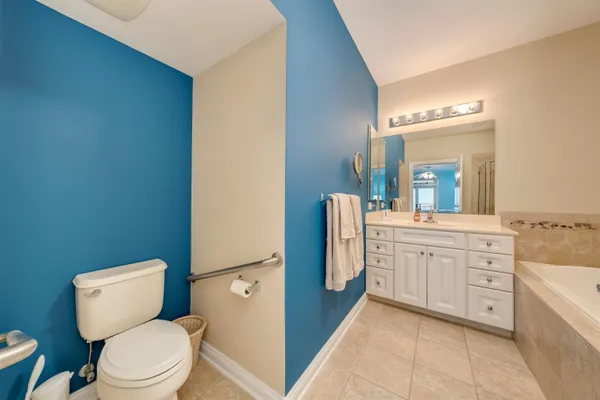 a bathroom with a granite countertop toilet sink and mirror