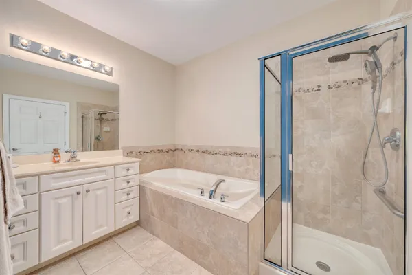 a bathroom with a tub sink and mirror