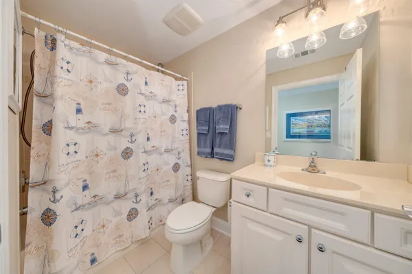 a bathroom with a sink a toilet and shower curtain