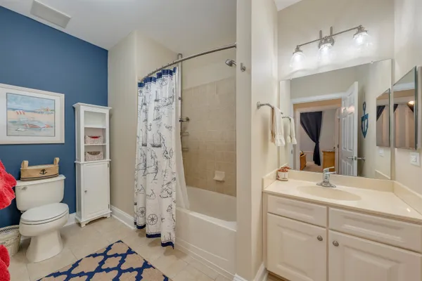 a bathroom with a bathtub shower sink vanity and toilet