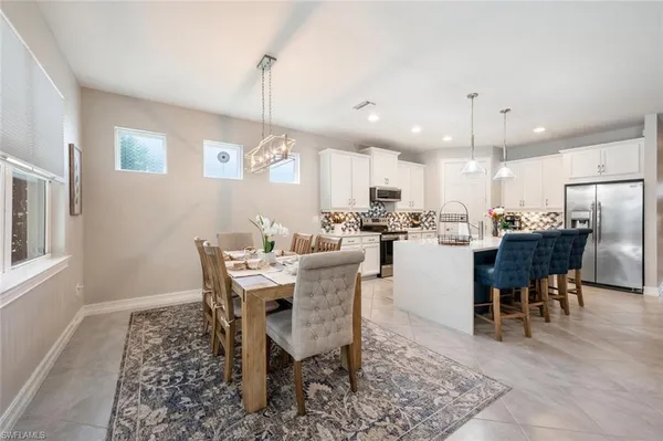 a dining room with a table chairs and a kitchen view
