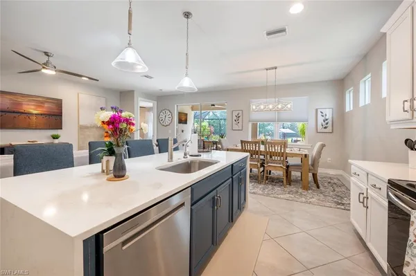 a kitchen with kitchen island a sink dining table and chairs
