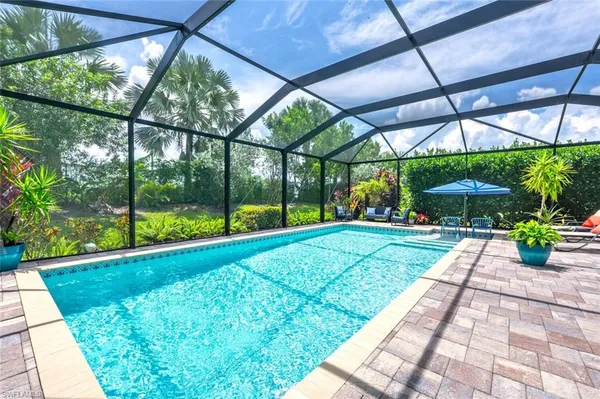 a view of pool with umbrella and table under an umbrella