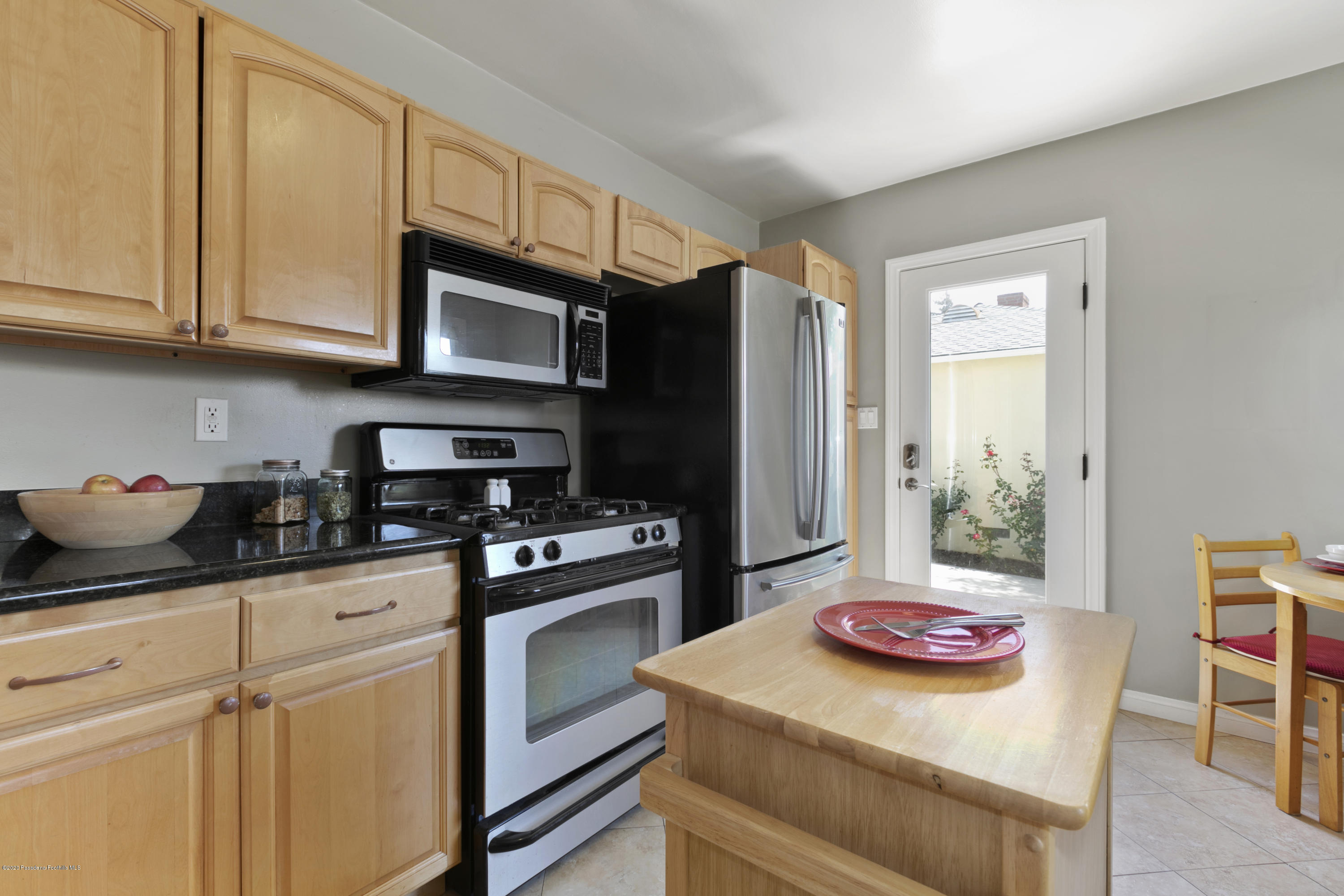 1231 Meadowbrook Road Altadena, CA 91001 - Photo 12 of 25 a kitchen with stainless steel appliances granite countertop a refrigerator a stove a sink dishwasher and white cabinets with wooden floor