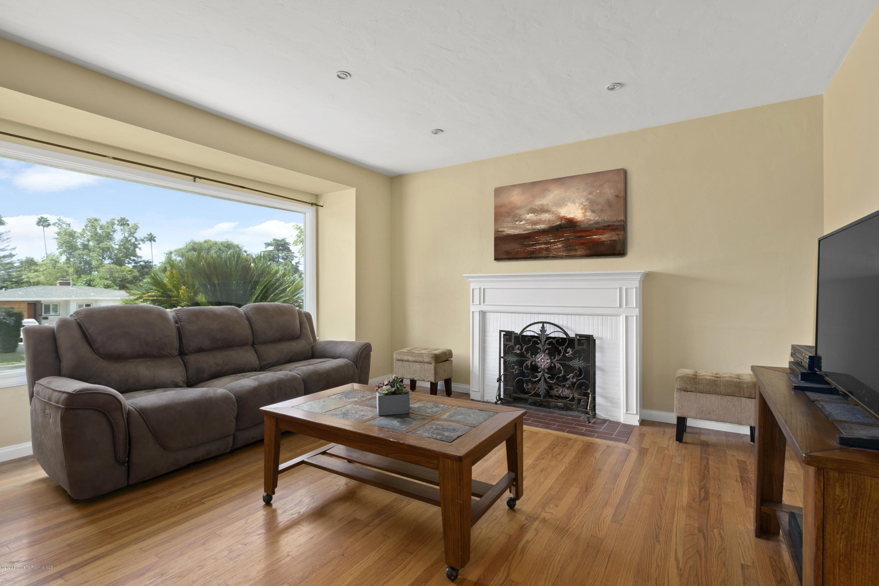 1231 Meadowbrook Road Altadena, CA 91001 - Photo 5 of 25 a living room with furniture a fireplace and a flat screen tv