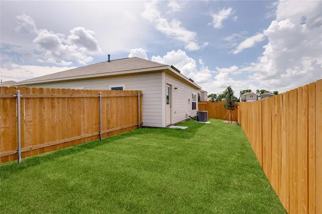 a view of a backyard with potted plants and wooden fence