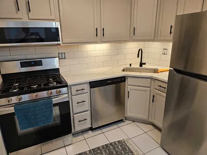 a kitchen with cabinets appliances and a counter