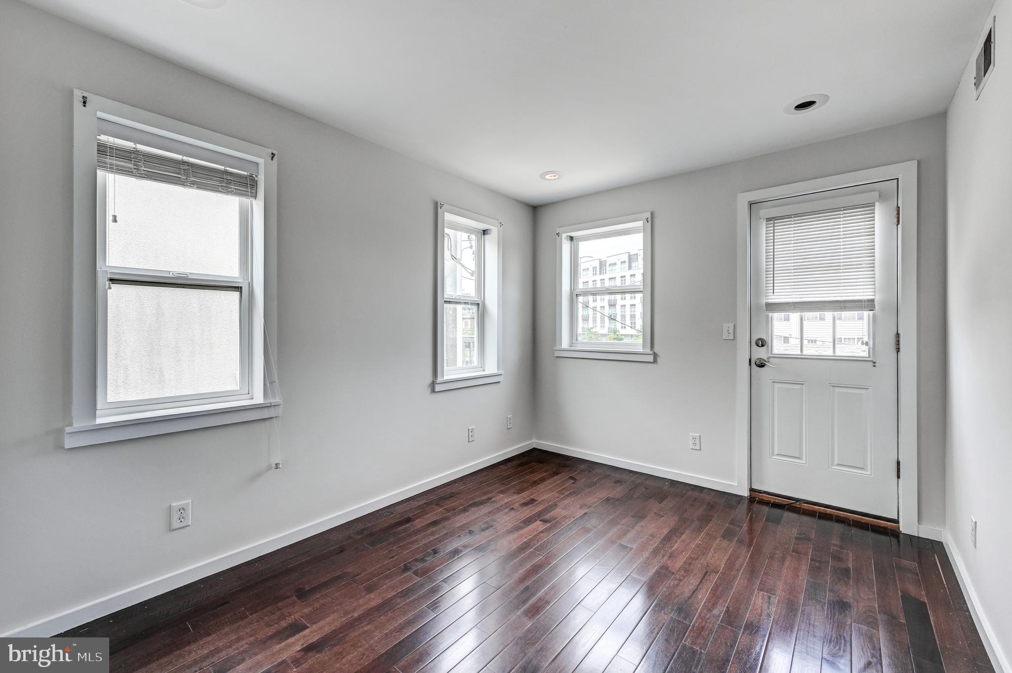 136 West Ostend Street Baltimore, MD 21230 - Photo 19 of 33 an empty room with wooden floor and windows