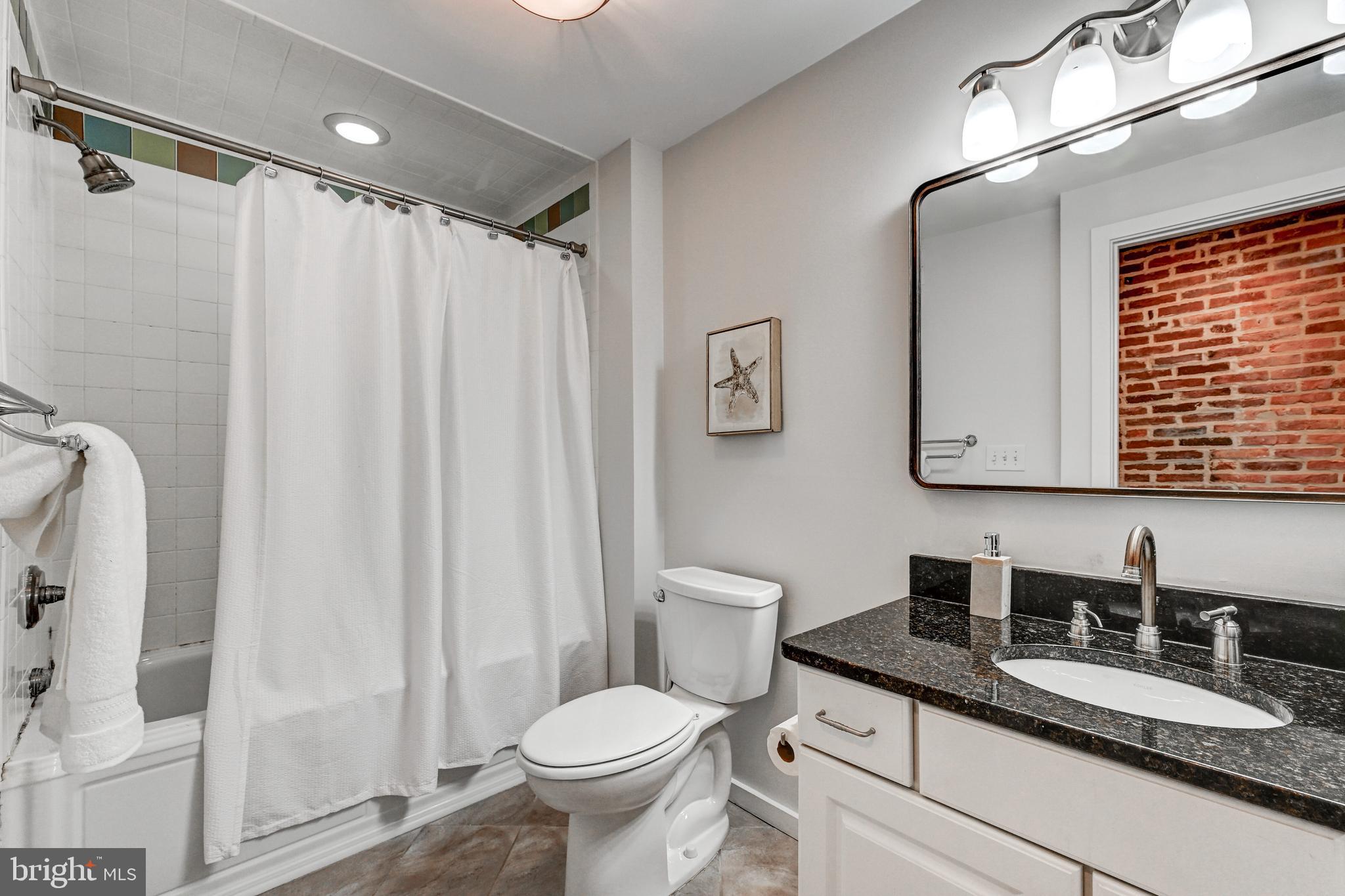 136 West Ostend Street Baltimore, MD 21230 - Photo 21 of 33 a bathroom with a granite countertop sink mirror vanity and toilet