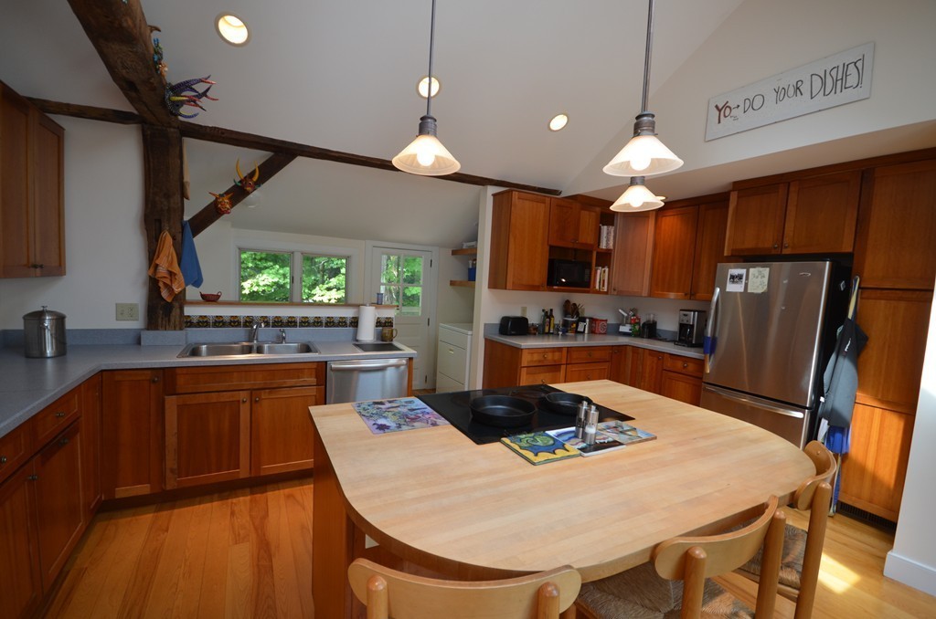 713 Bay Road Amherst, MA 01002 - Photo 7 of 29 a kitchen with stainless steel appliances a table chairs refrigerator and microwave