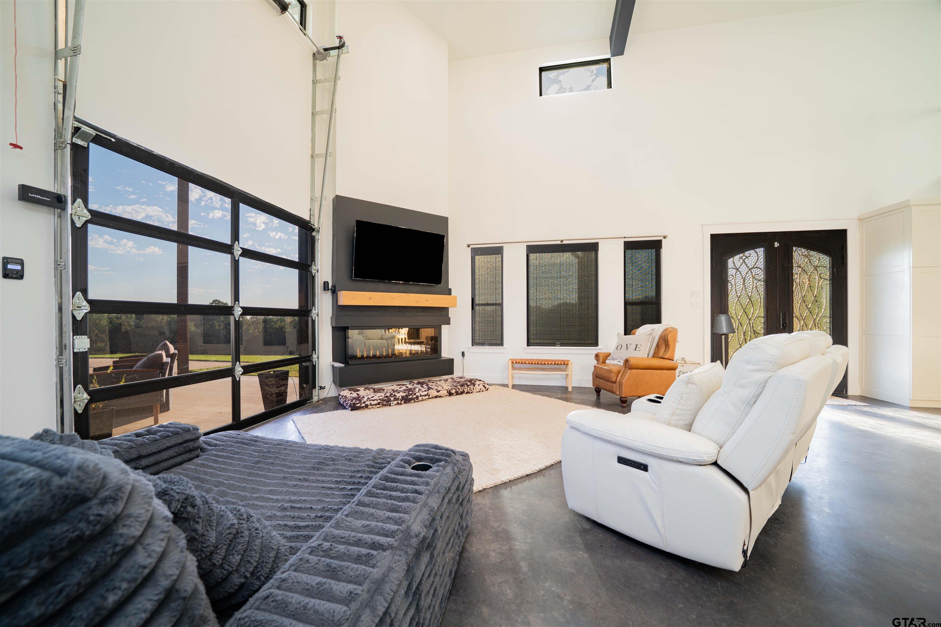 1258 Fire Tower Road Hallsville, TX 75650 - Photo 31 of 45 a living room with furniture a flat screen tv and floor to ceiling window