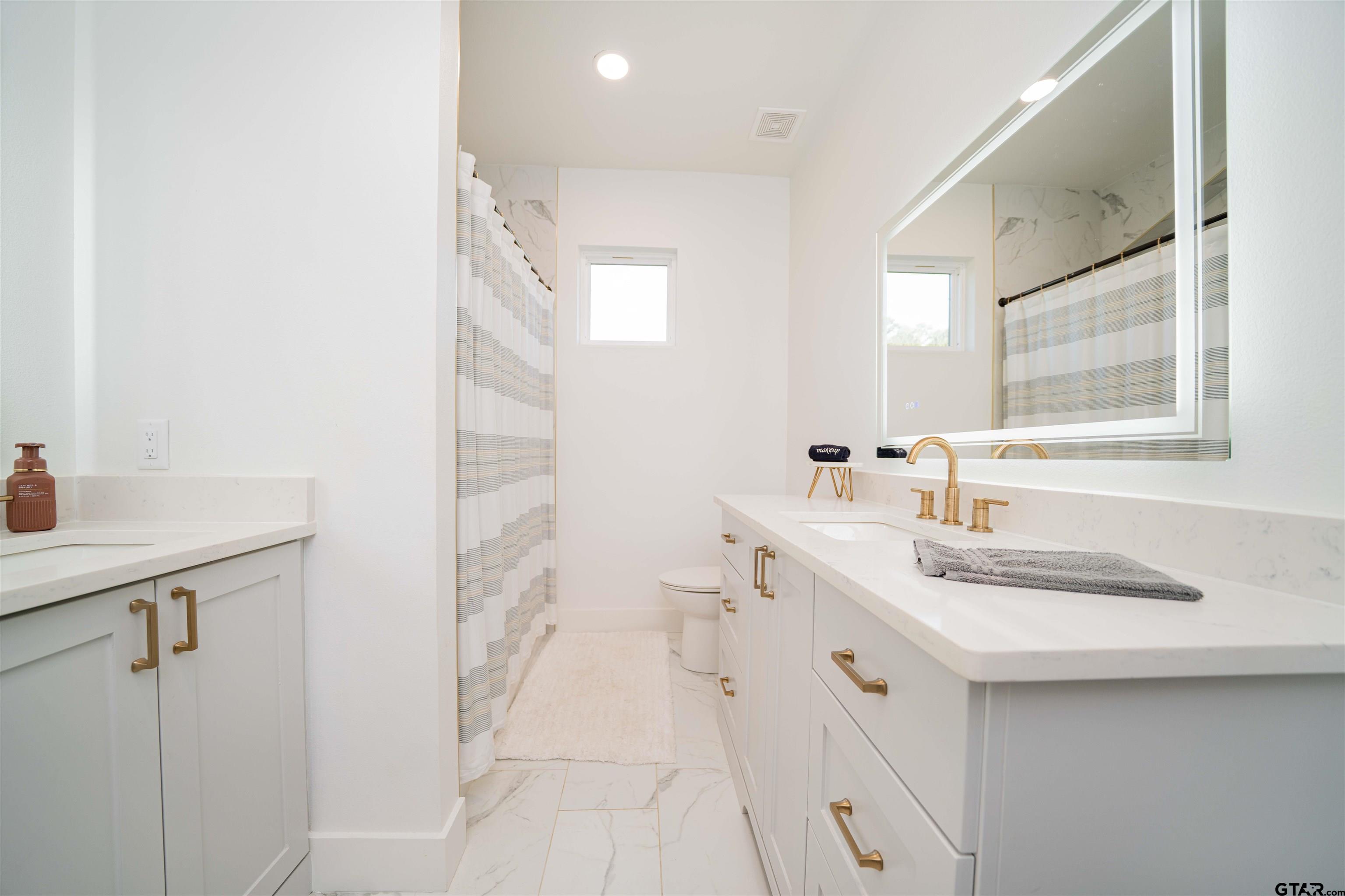 1258 Fire Tower Road Hallsville, TX 75650 - Photo 40 of 45 a bathroom with a sink double vanity and a mirror