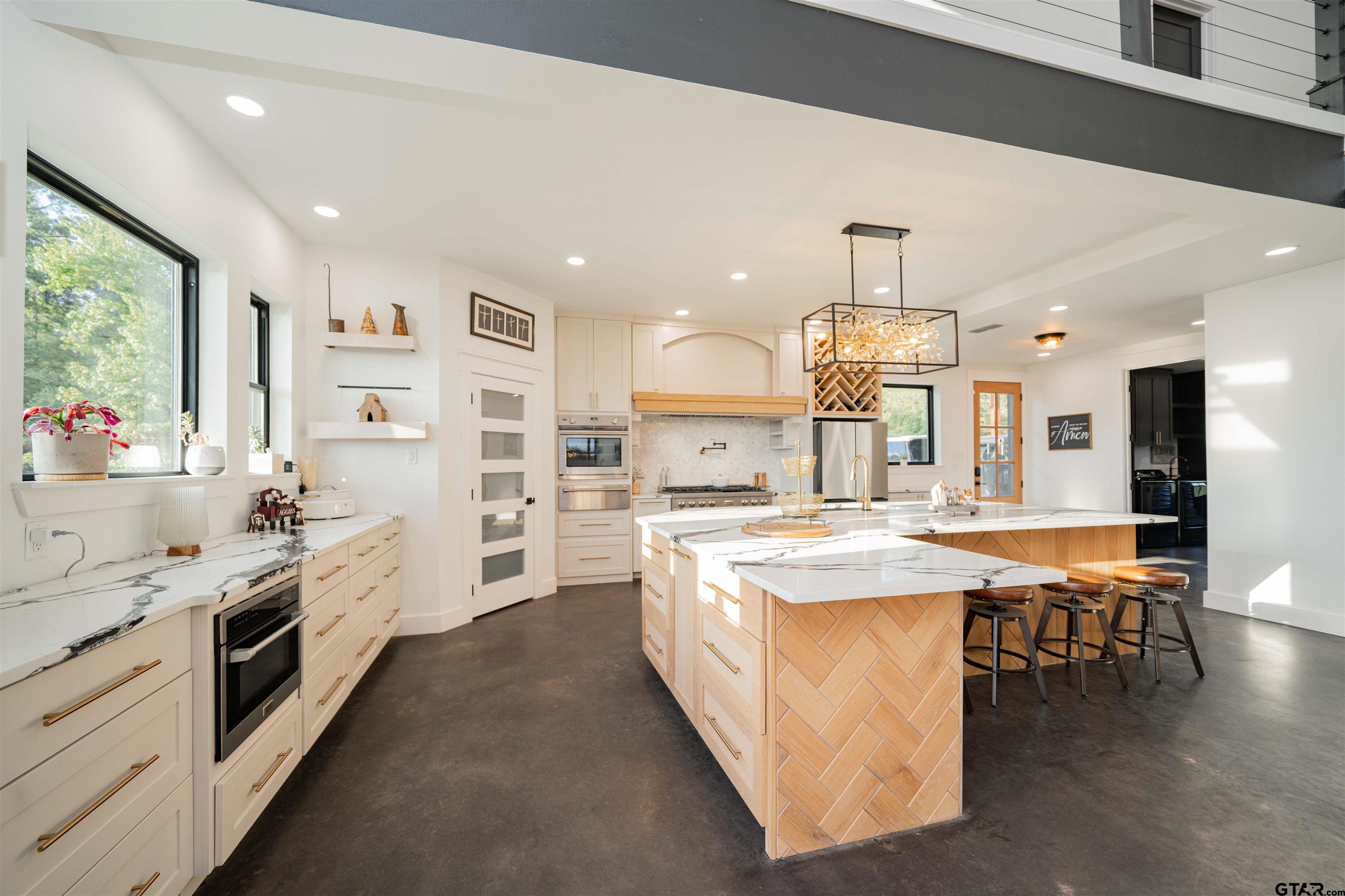 1258 Fire Tower Road Hallsville, TX 75650 - Photo 4 of 45 a large kitchen with kitchen island a stove a table a sink and a refrigerator