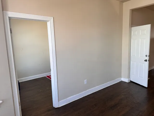 an empty room with wooden floor and closet