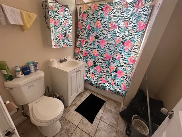 a bathroom with a toilet and a shower curtain