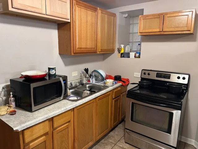 a kitchen with granite countertop cabinets stainless steel appliances and wooden floor