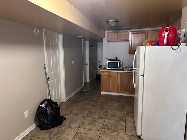 a kitchen with refrigerator and a stove