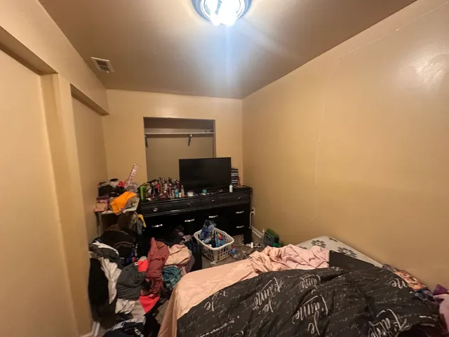 a bedroom with a bed and a computer on the desk