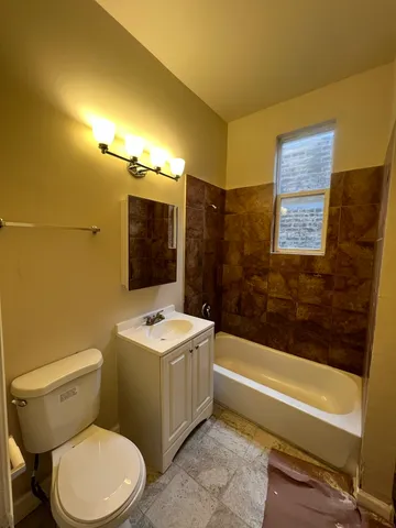 a bathroom with a sink mirror vanity and toilet