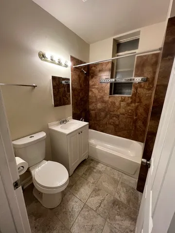 a white toilet sitting next to a bath tub