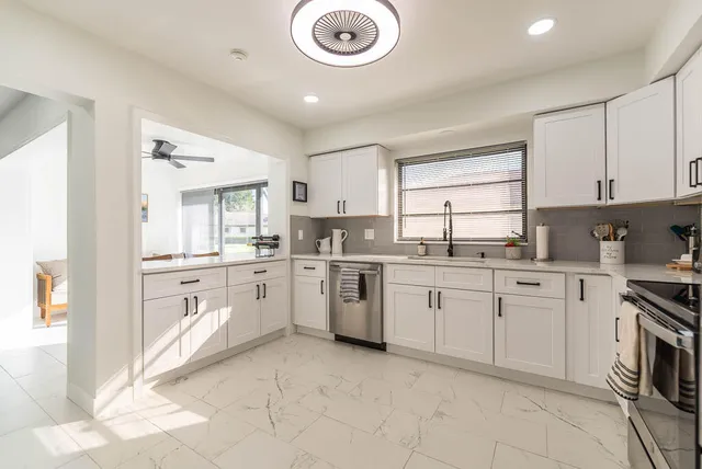 a kitchen with cabinets appliances and a window