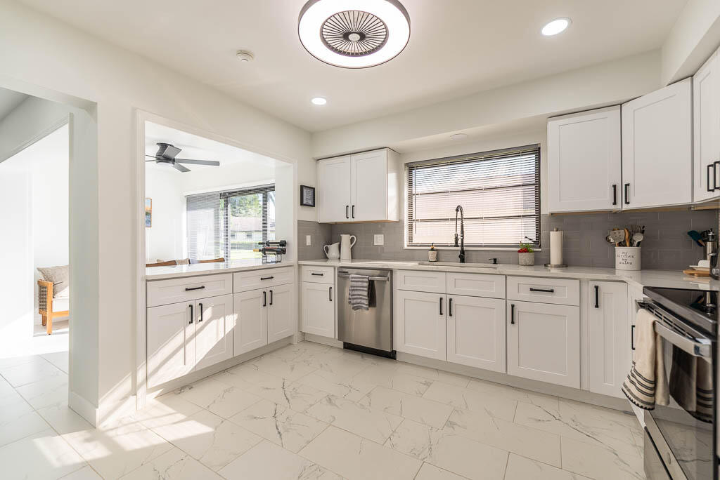 4760 Greentree Way, Unit A Boynton Beach, FL 33436 - Photo 12 of 30 a kitchen with cabinets appliances and a window