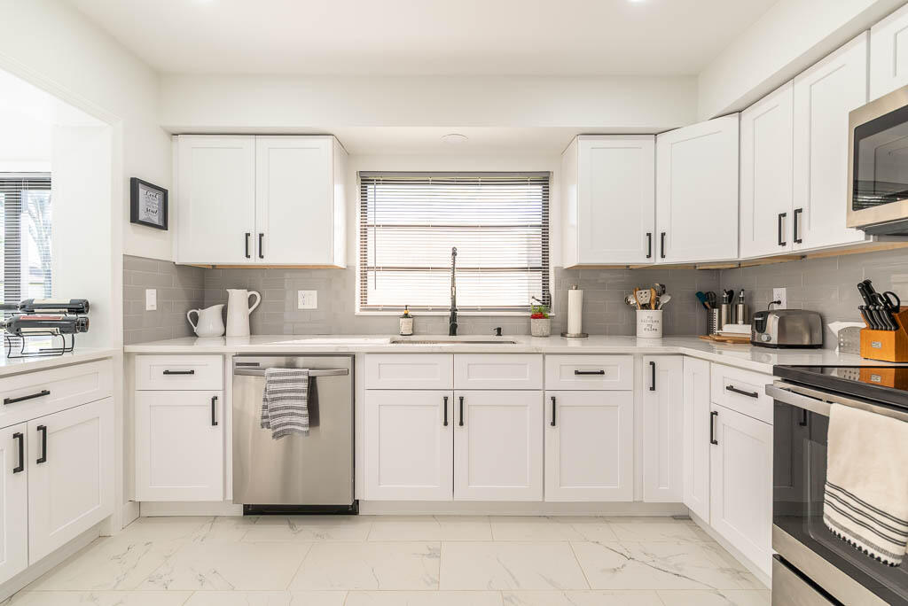 4760 Greentree Way, Unit A Boynton Beach, FL 33436 - Photo 13 of 30 a kitchen with cabinets appliances a sink and a window