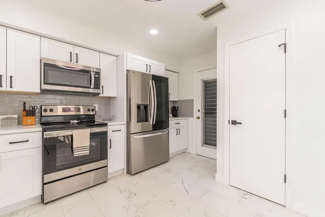 a kitchen with stainless steel appliances a refrigerator sink and microwave