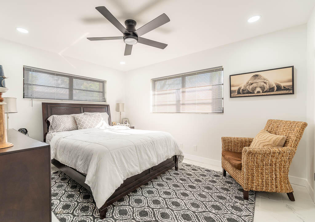 4760 Greentree Way, Unit A Boynton Beach, FL 33436 - Photo 20 of 30 a bedroom with a bed and chair