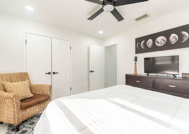 a bedroom with a bed and a flat screen tv