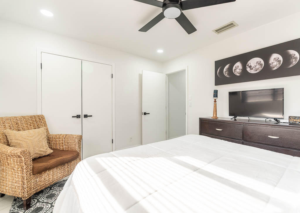 4760 Greentree Way, Unit A Boynton Beach, FL 33436 - Photo 21 of 30 a bedroom with a bed and a flat screen tv