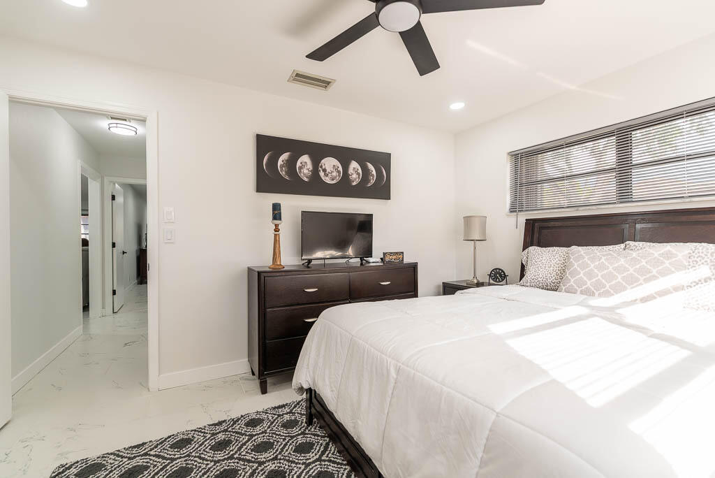 4760 Greentree Way, Unit A Boynton Beach, FL 33436 - Photo 22 of 30 a bedroom with a bed and cabinets