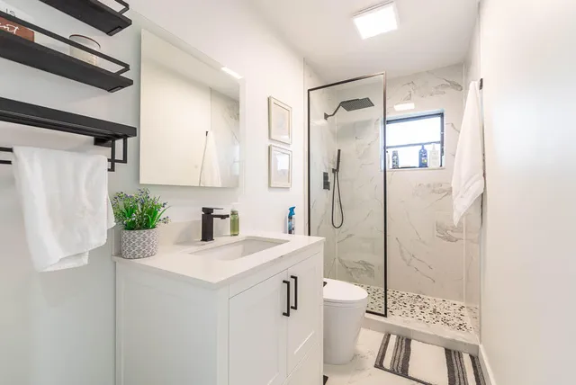 a bathroom with a sink a toilet and shower