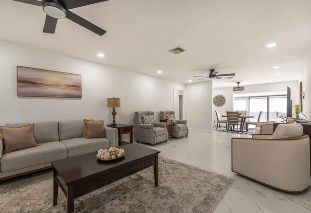 a living room with furniture and a view of kitchen