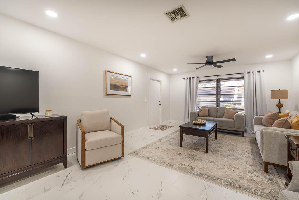4760 Greentree Way, Unit A Boynton Beach, FL 33436 - Photo 6 of 30 a living room with furniture and a flat screen tv