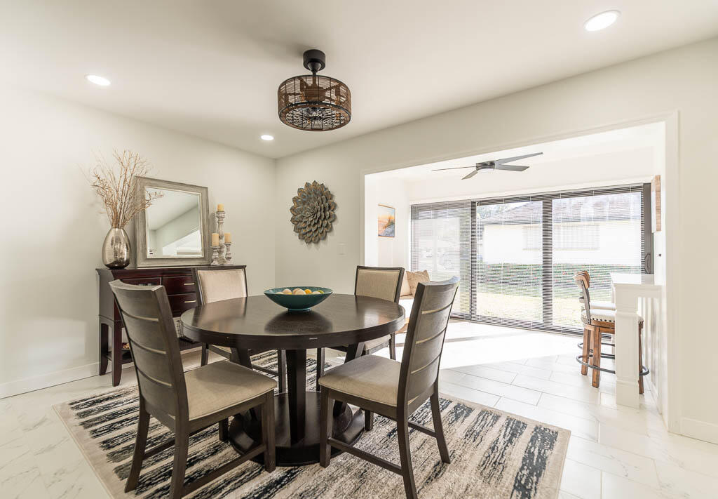 4760 Greentree Way, Unit A Boynton Beach, FL 33436 - Photo 7 of 30 a view of a dining room and livingroom with furniture wooden floor and a rug